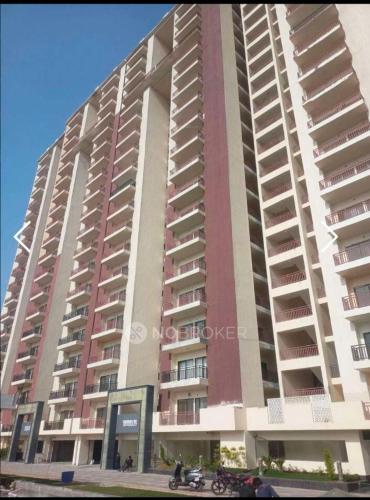 un gran edificio de apartamentos con una motocicleta estacionada frente a él en The Golden Gate 2BHK Fully Airconditioned Flat, en Ghaziabad