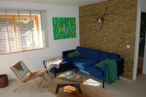 a living room with a blue couch and a chair at Ferienwohnung im Architektenhaus in Reken