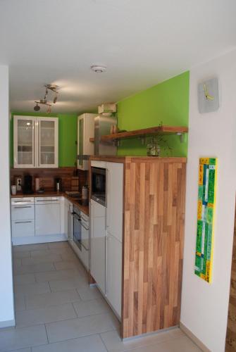 a kitchen with green walls and white appliances at Ferienwohnung im Architektenhaus in Reken