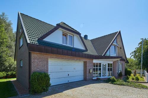 a house with a garage and a roof at Doppelzimmer mit kleiner Pantryküche Gästehaus Unter den Linden in Mühbrook