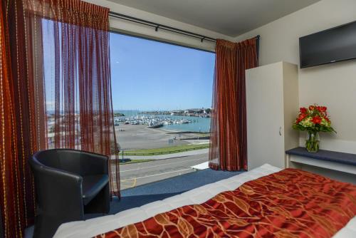 Habitación de hotel con cama y ventana grande en Bluewater Hotel, en Napier