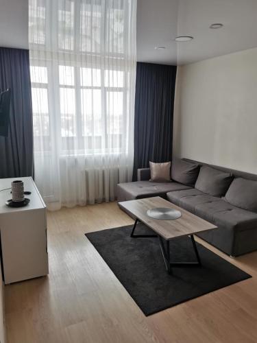 a living room with a couch and a coffee table at Lauros 1 & R Apartamentai in Panevėžys