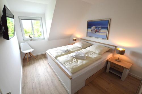 a bedroom with a large white bed and a window at Stadthaus 1, inkl 1 Parkplatz in Fehmarn