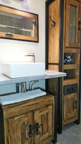 La salle de bains est pourvue d'un lavabo et d'une armoire en bois. dans l'établissement La Maison d 'Isa Mèze appartement RdC, à Mèze