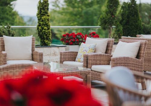 a patio with wicker chairs and a table and flowers at Wellness & Spa Hotel Kaskady in Sliač