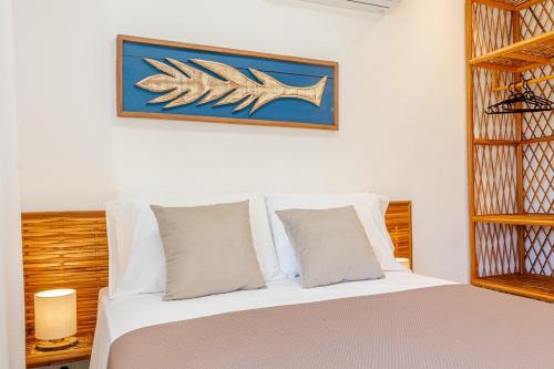 a bedroom with a bed with a fish picture on the wall at Dom Ortiz in Marau