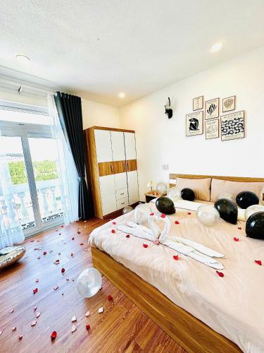 a bedroom with a bed with red rose petals on the floor at Nhà Của Nắng - Homestay Đà Lạt in Da Thanh