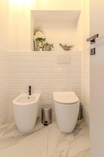 a white bathroom with a toilet and a sink at Blue como Luxury suite in Como