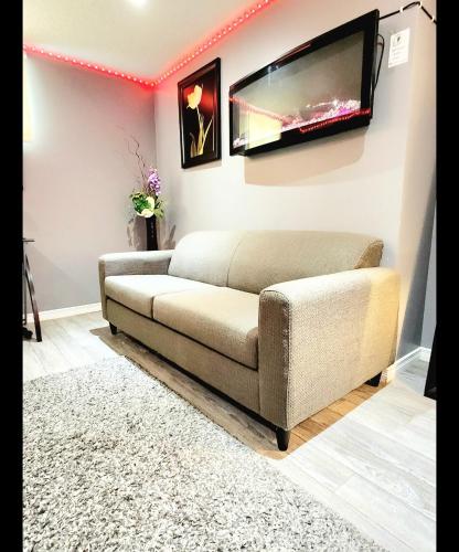 a living room with a couch and a flat screen tv at Staycation Studio Apartment, Private kitchen , Washroom, Micro Gym & Free Onsite Parking in London