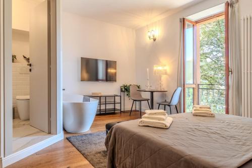 a room with a bed and a bathroom with a tub at Blue como Luxury suite in Como
