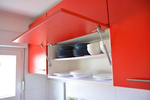 a red cabinet with bowls and plates in a kitchen at Apartment Mirela in Sarajevo