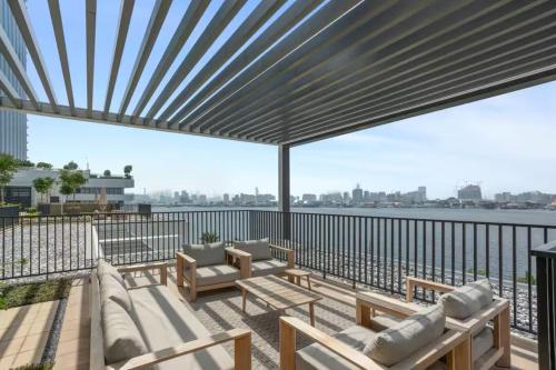 a patio with a view of the water at SettlerHomes - Chic Creek Edge 1BR With Harbour View in Dubai