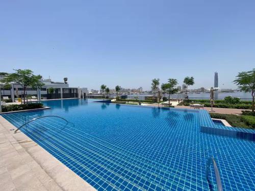 a large blue swimming pool in a resort at SettlerHomes - Chic Creek Edge 1BR With Harbour View in Dubai