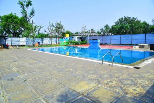 an empty swimming pool at a resort at Sampigeheritage resot in Koppal