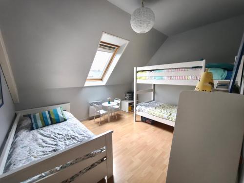 une chambre avec deux lits superposés et une table dans l'établissement L'écume des Jours, à Bréville-sur-Mer