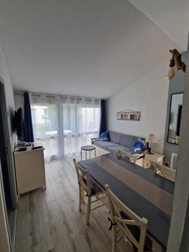 un salon avec une table et un canapé dans l'établissement Charmante petite maison pour 4 personnes CDC FR90C10G, à Dolus-d'Oléron