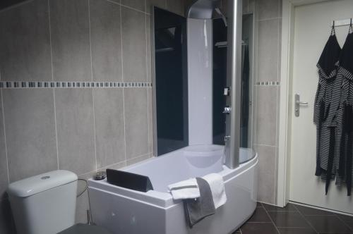 a bathroom with a toilet and a bath tub at Echappée Belle in Jalhay