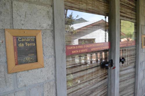 a door to a building with a sign on it at Pousada Rota dos Pássaros in São Bento do Sapucaí
