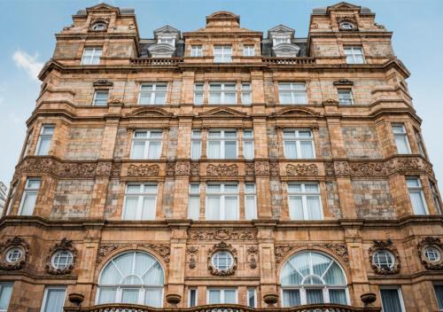 a tall brick building with windows at Victory House Leicester Square in London