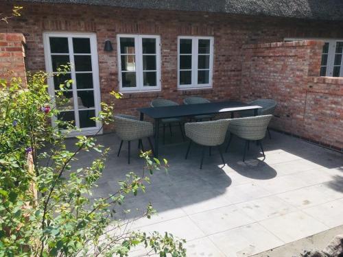 eine Terrasse mit einem schwarzen Tisch und Stühlen in der Unterkunft Haus Boldix Whg 6 St Barth in Boldixum