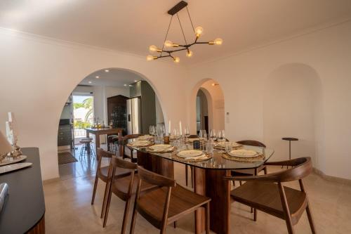a dining room with a long table and chairs at Luxurious Villa - Pool, Hot Tub, Cinema and Golf in Vilamoura
