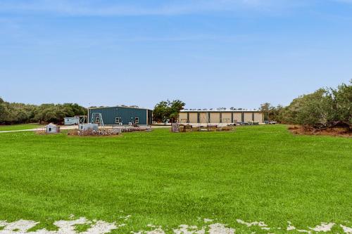 a large green field with a building in the background at Salty Getaway in Lamar