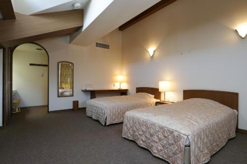 a hotel room with two beds and a table at ホテル レムナント鶯宿 in Shizukuishi