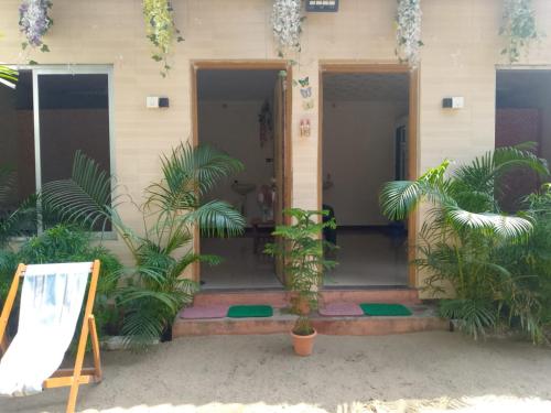 a building with palm trees in front of it at Holiday Tourisms Group of Homestay Rooms Scuba Diving Boating Watersports-Tarkarli-Devbag Beach in Bhogwe