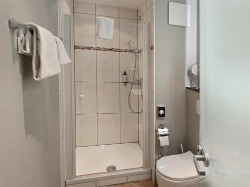 a bathroom with a shower and a toilet at DORMERO Hotel Coburg in Coburg