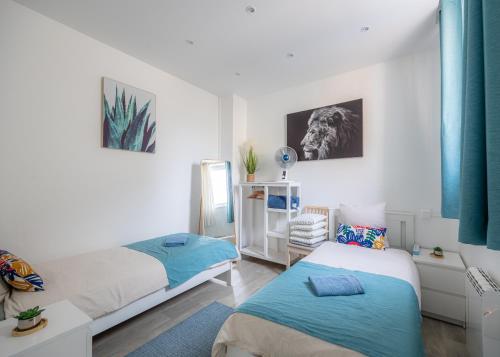 une chambre avec deux lits et un miroir dans l'établissement Blue House - Parking - Centre ville, à Reims