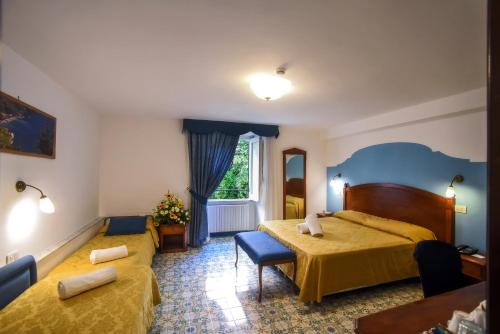 a hotel room with two beds and a window at Amalfi Hotel centro storico in Amalfi