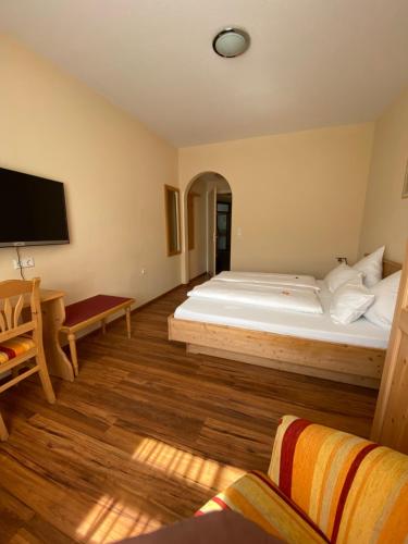 a bedroom with a large bed and a flat screen tv at Hotel Klosterhof in St. Blasien