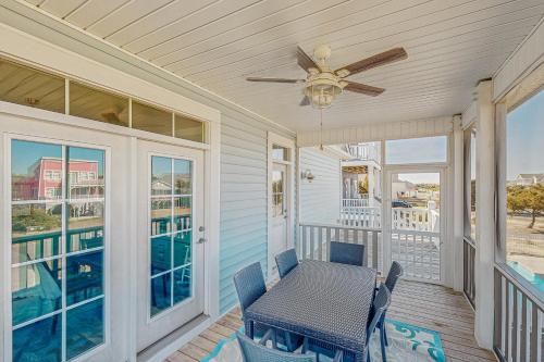 a porch with a table and chairs and a ceiling fan at Eagles Nest in Oak Island
