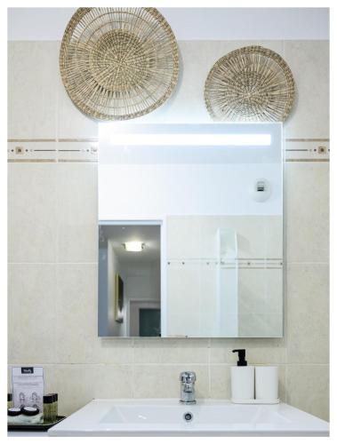 une salle de bain avec un lavabo et un miroir dans l'établissement Confortable 3P avec terrasse, proche Disney et Paris, à Montévrain