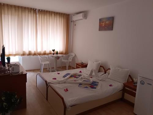 a bedroom with two beds and a table with chairs at Стаи за гости Ники in Nesebar