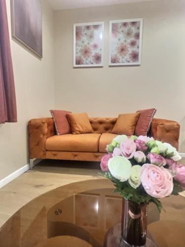 a living room with a couch and a table with flowers at Le Nid de Clichy in Clichy