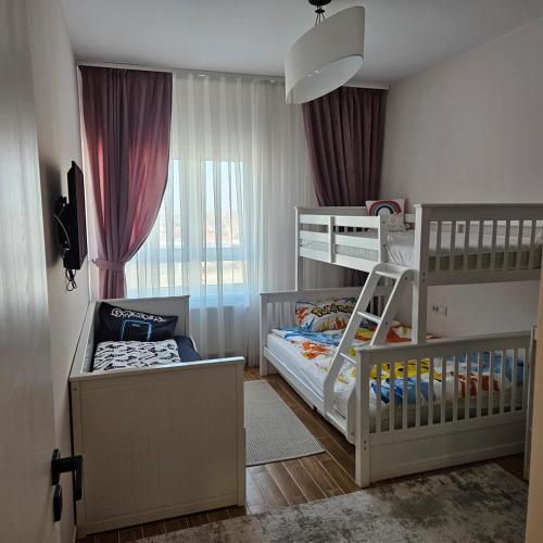 a bedroom with two bunk beds and a window at Dan's Apartament in Seleuş