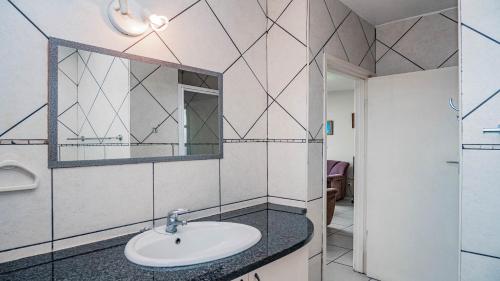 a bathroom with a sink and a mirror at Peacehaven Beachfront Property - Scottburgh KZN in Scottburgh