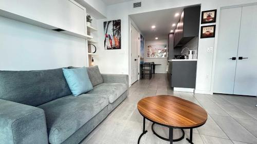 a living room with a couch and a wooden table at Sky-High oasis Large Studio POOL & GYM in Miami