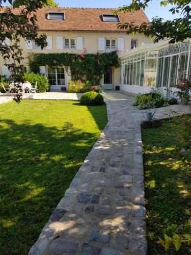 a house with a walkway in front of a yard at Depuis la verrière in Bleury
