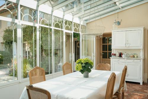 a dining room with a table with a vase of flowers at Depuis la verrière in Bleury