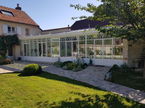 a house with a conservatory with a lot of glass at Depuis la verrière in Bleury
