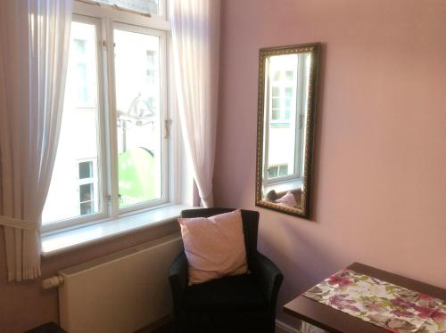 a room with a mirror and a chair and a window at Komfort Appartment Hugo in Eckernförde