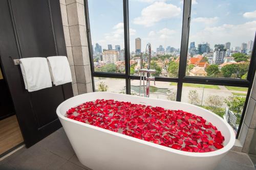 a bath tub filled with red roses in front of a window at GLOW PARK HOTEL Grand Royal Palace in Phnom Penh