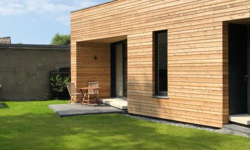 una casa de madera con una mesa y sillas en un patio en -"Strandhaus Friedrich"-, en Dierhagen