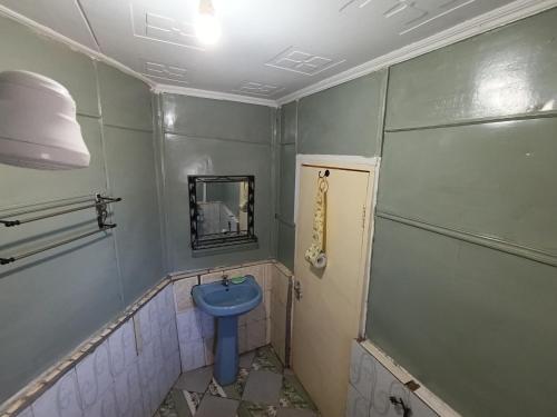 a bathroom with a blue toilet and a mirror at The Craal in Oloitokitok 