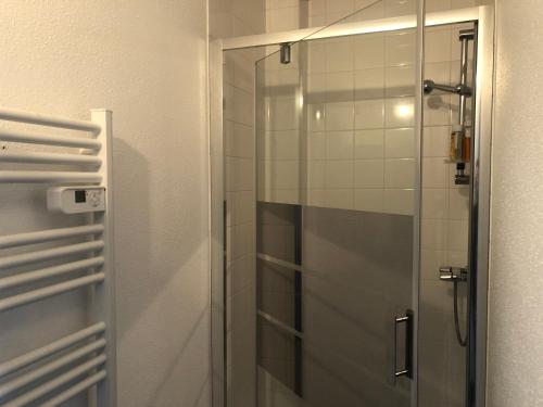 a shower with a glass door in a bathroom at La suite du garagiste in Boulot
