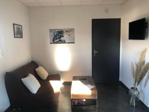 a living room with a couch and a table at La suite du garagiste in Boulot