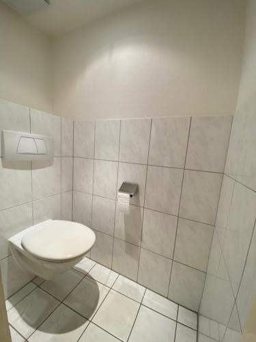 a bathroom with a toilet and a tiled wall at Hotel Klosterhof in St. Blasien