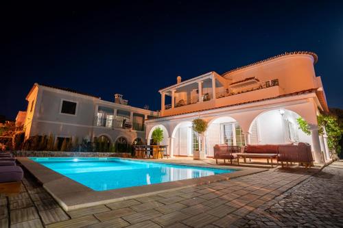 a villa with a swimming pool at night at Luxurious Villa - Pool, Hot Tub, Cinema and Golf in Vilamoura
